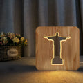 Solid wood hollow night lamp with warm white LED light on a surface.