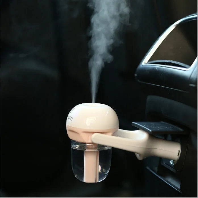 Compact blue portable car humidifier and air freshener diffuser on a car dashboard.
