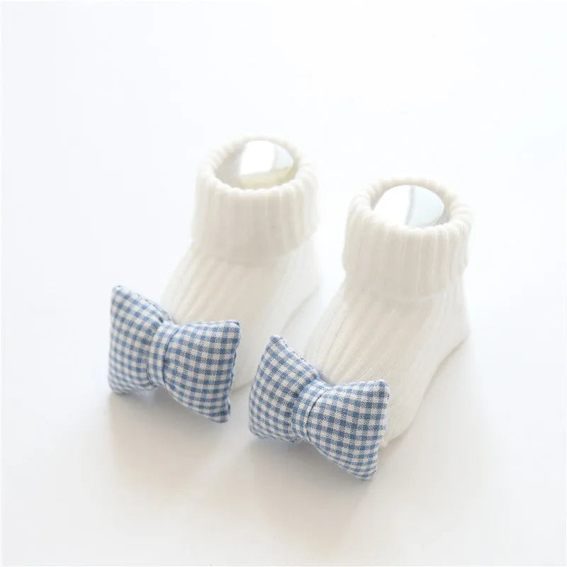 Cotton baby socks in multiple colours and prints including panda, lion, bows, and stars on a white background.