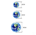 Glow in the dark 3D planet Earth wall sticker on a dark blue background, showing its luminous effect.