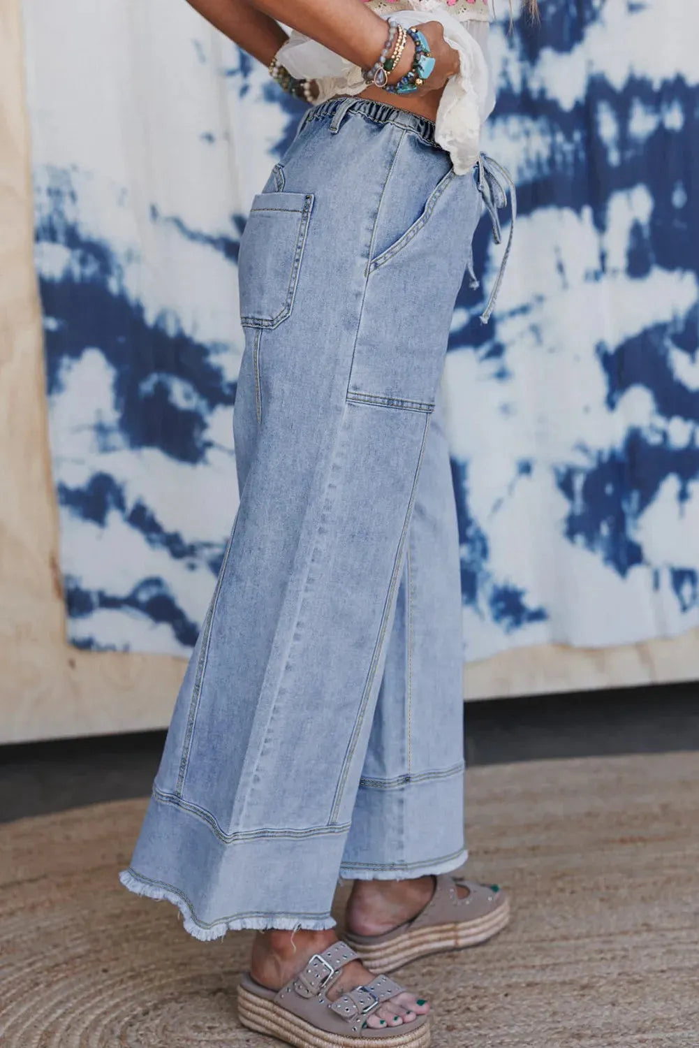 Beau Blue women's wide leg denim trousers featuring a drawstring waistband and raw hem detailing.