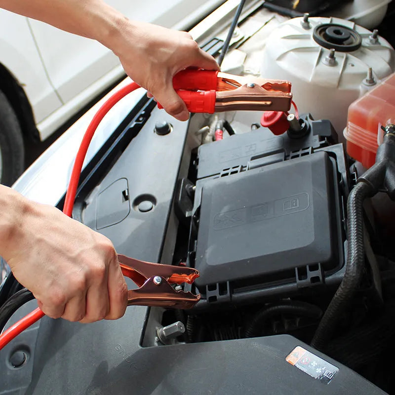 Black and red car battery jumper cables with clips for emergency vehicle jump-starting