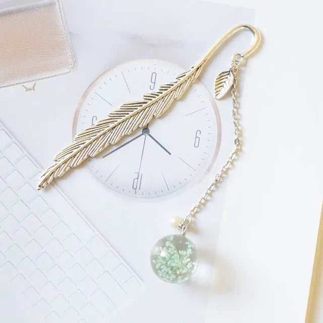Dried flower specimen encased in metal alloy bookmark pendant measuring 12cm by 2cm