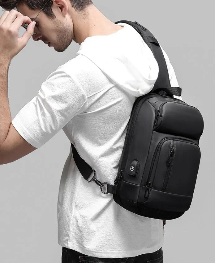 Black PVC outdoor leisure shoulder bag showing air cushion strap and organisational pockets