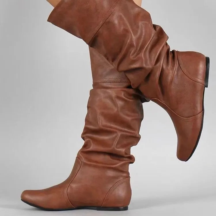 Women's slip-on knee high flat boots in artificial PU upper with round toe and rubber sole