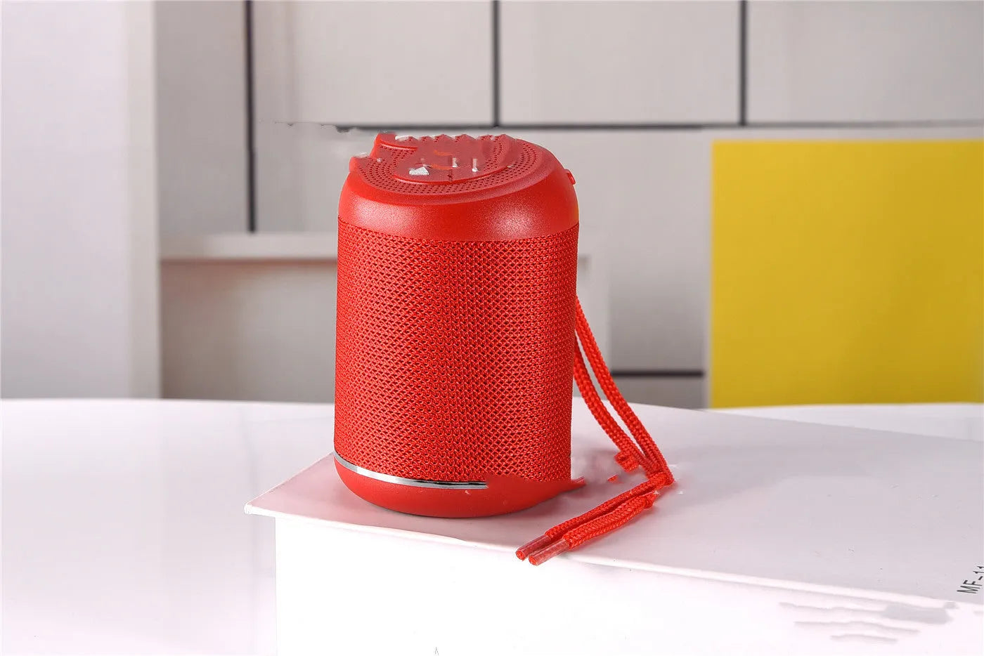 Portable outdoor Bluetooth subwoofer in multiple colours showing button controls for radio and playback functions.