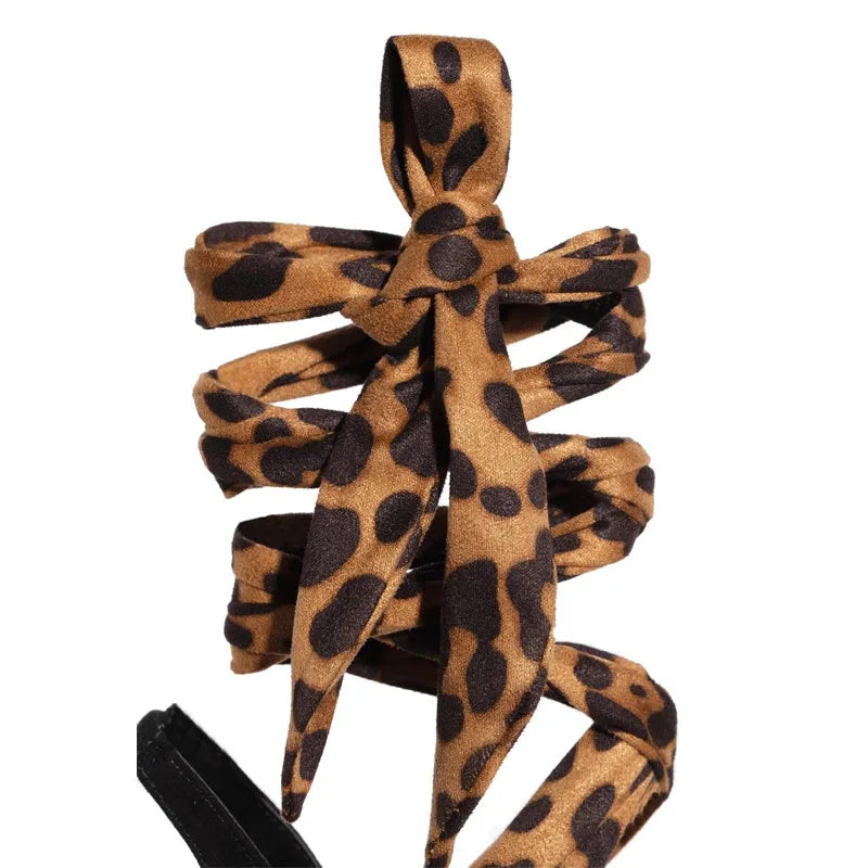 Light brown leopard print women's high heel sandals with cross straps and a fine heel.