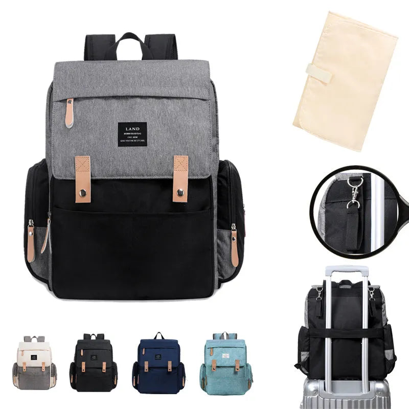LAND Mommy large grey diaper backpack with multiple compartments and a changing mat laid out