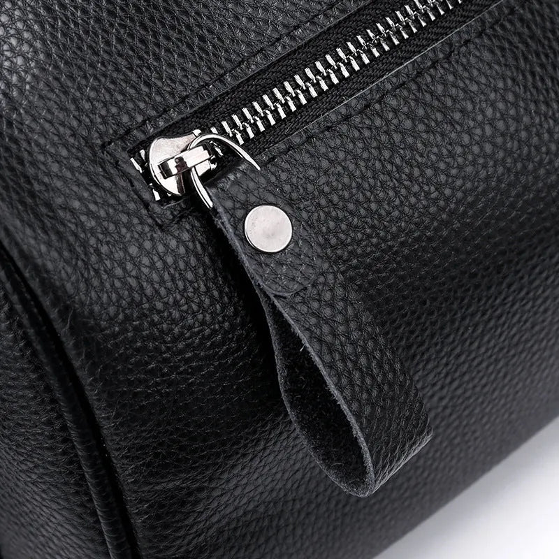 Black genuine leather crossbody bag with one-shoulder strap showing interior polyester lining