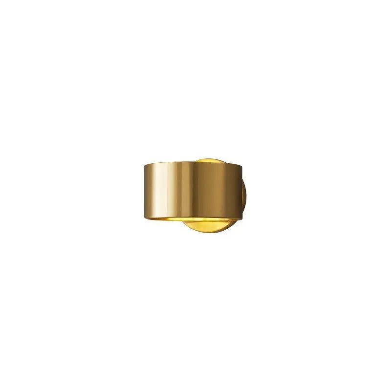 Modern copper wall light fixture in gold finish mounted on a wall