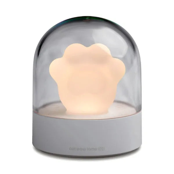 Grey cat paw shaped USB rechargeable night light and music box lamp on a desktop.