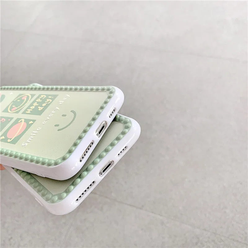 Green iPhone case with smiley face and white polka dot geometric design on the back.