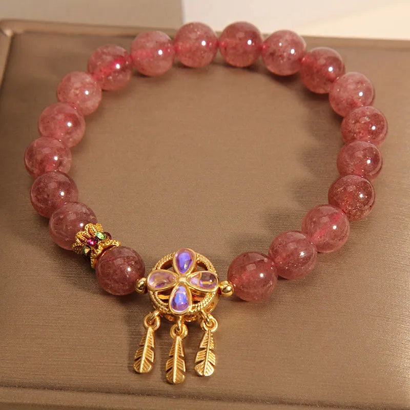 Women's strawberry quartz crystal bracelet with four leaf dream catcher pendant.