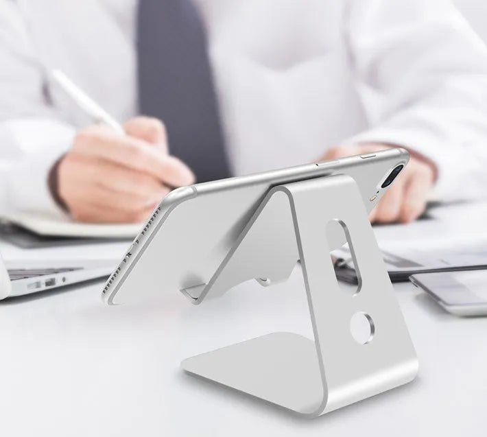 Aluminium alloy universal phone and tablet holder stand in silver, shown holding a smartphone at an angle.