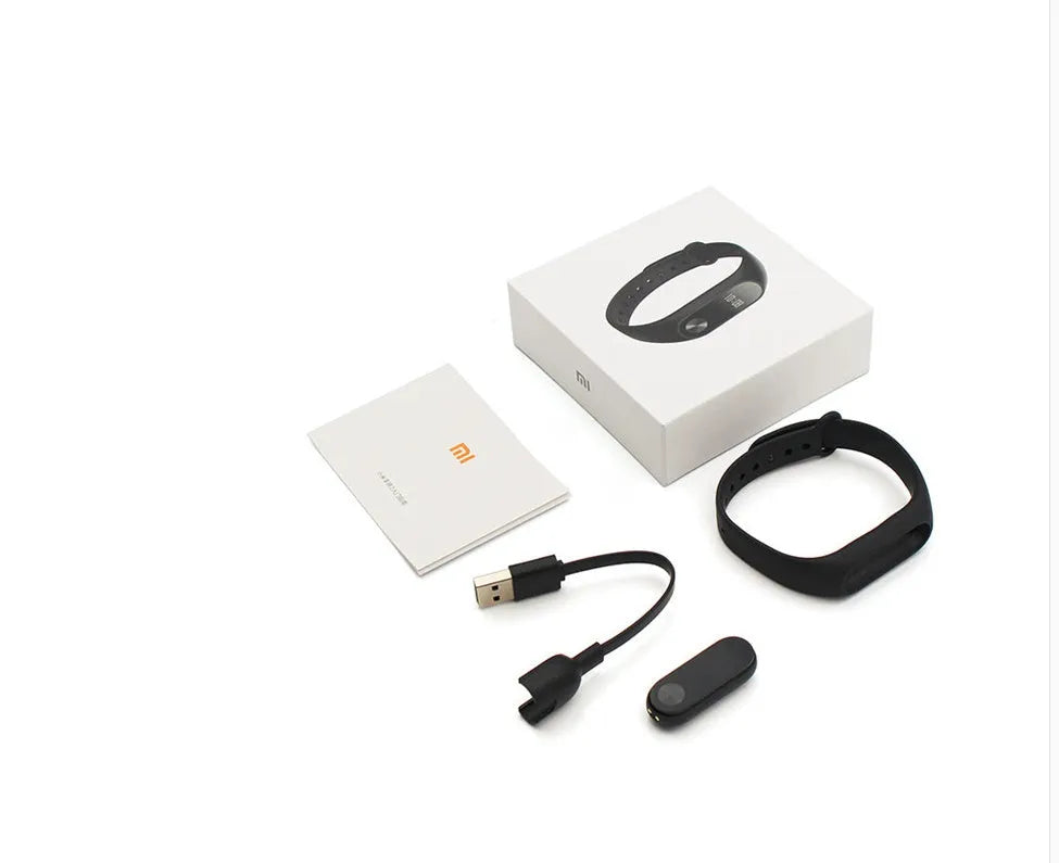 Black Xiaomi Mi Band 2 fitness tracker on wrist showing OLED screen with heart rate and step count.