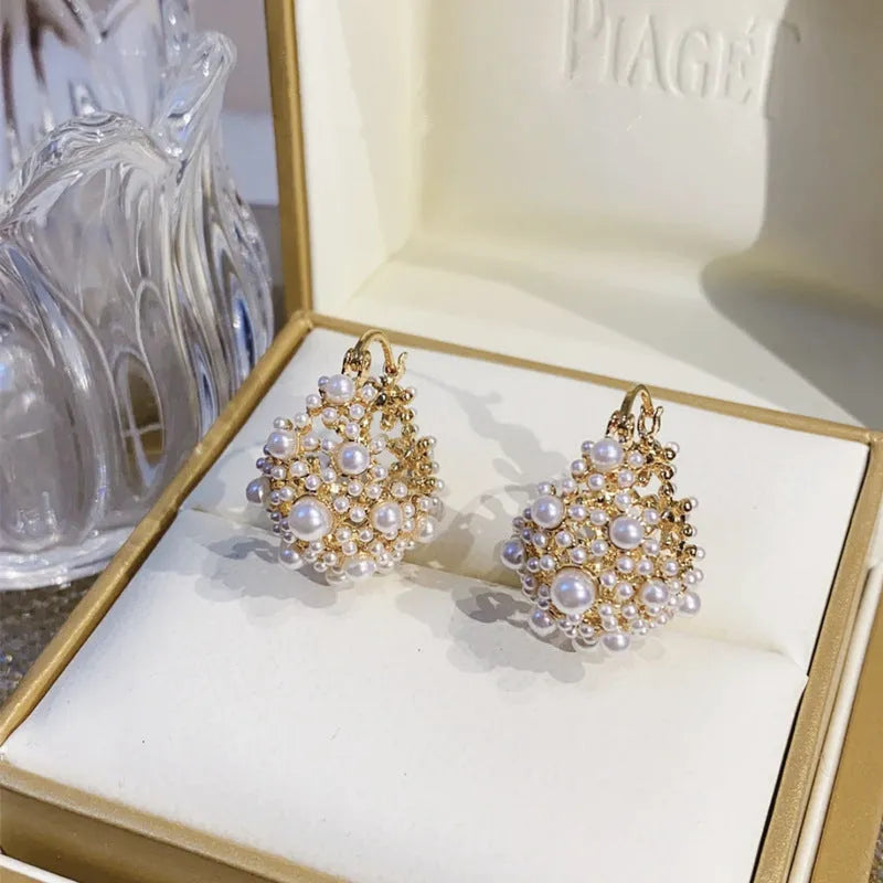 Gold-coloured copper flower basket earrings with small rice-shaped beads and pearl inlay detail.