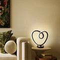 Black musical note shaped Bluetooth light with remote control on a bedside table.