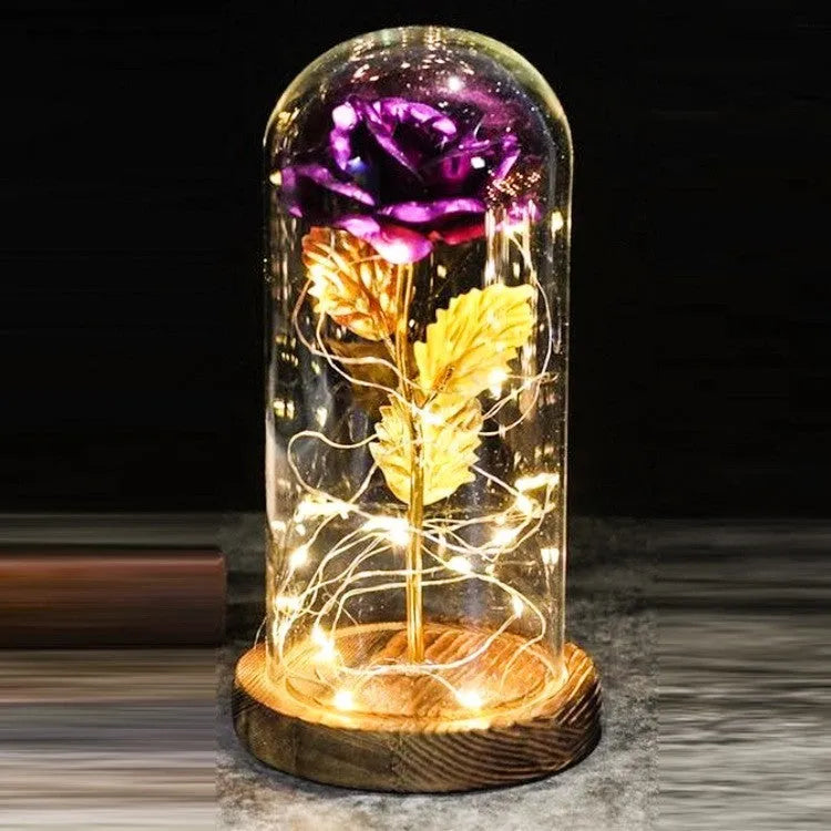 LED illuminated silk rose bouquet in a glass dome on a wooden base, with warm white lights.