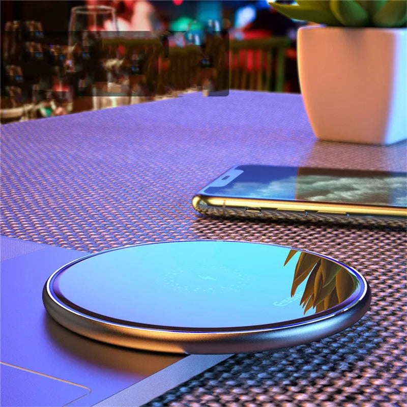 Black or white aluminium wireless charging pad showing soft LED light, for phones and headphones.
