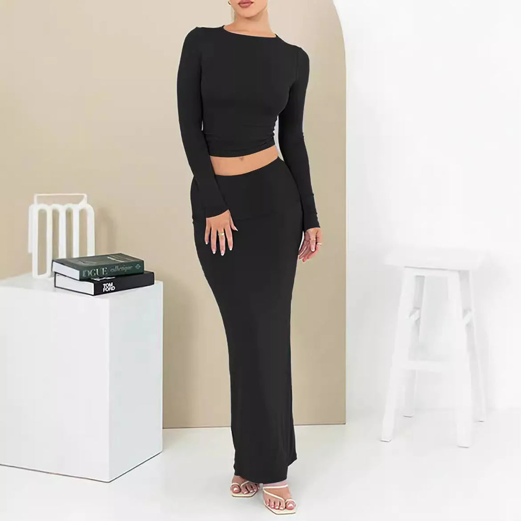 Women's black two-piece autumn suit with exposed navel top and long skirt.
