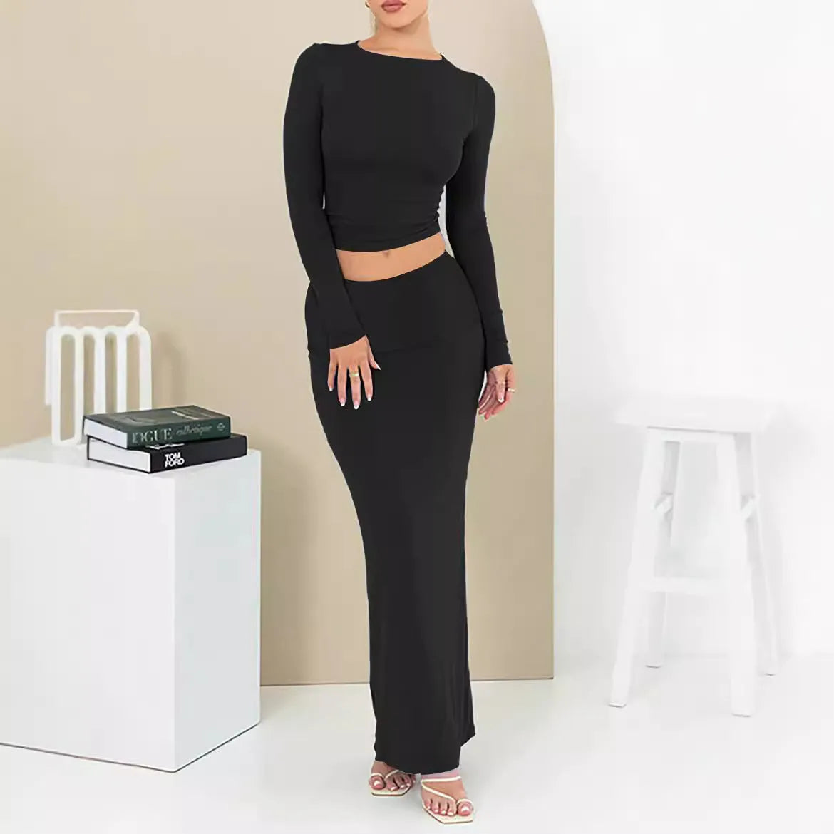 Women's black two-piece autumn suit with exposed navel top and long skirt.