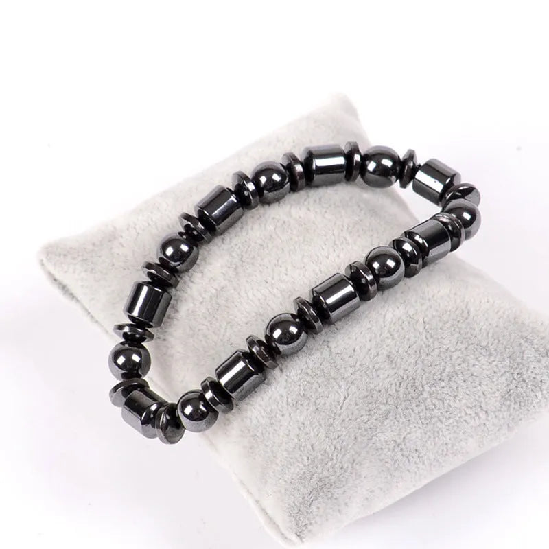 Black pentagram design magnetic therapy bracelet made from magnetite and hematite stones on a wrist.