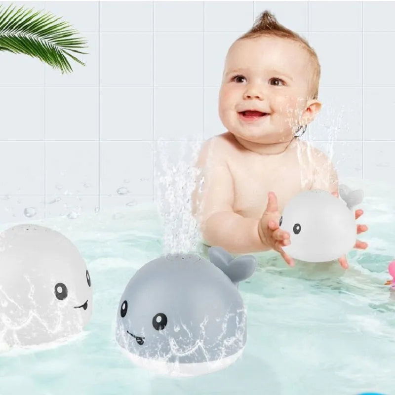 Blue and white whale bath toy with water spray and flashing lights for baby sensory play