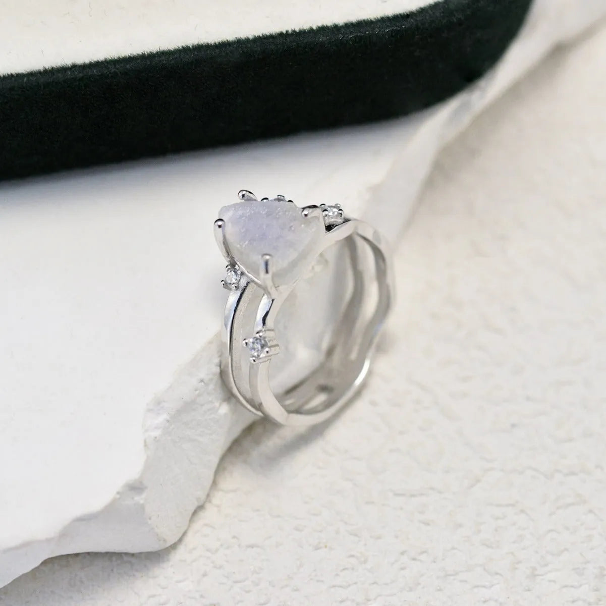 S925 sterling silver ring with irregular triangle shape holding a moonstone, shown in rose gold electroplated finish.
