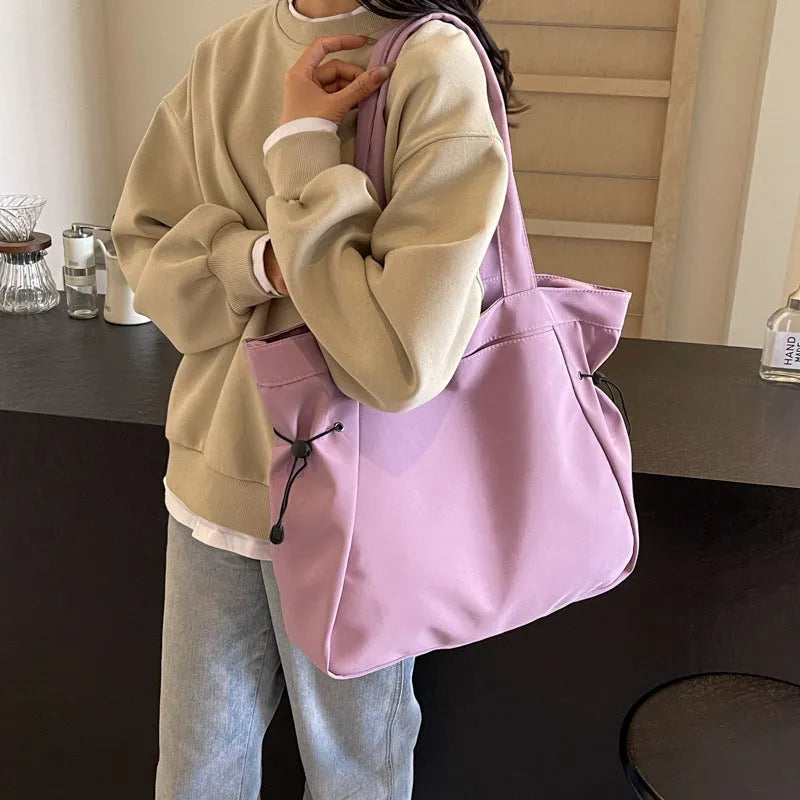 A foldable Oxford cloth commuter shoulder tote bag shown in one of five colours: black, brown, dark gray, light gray, or purple.