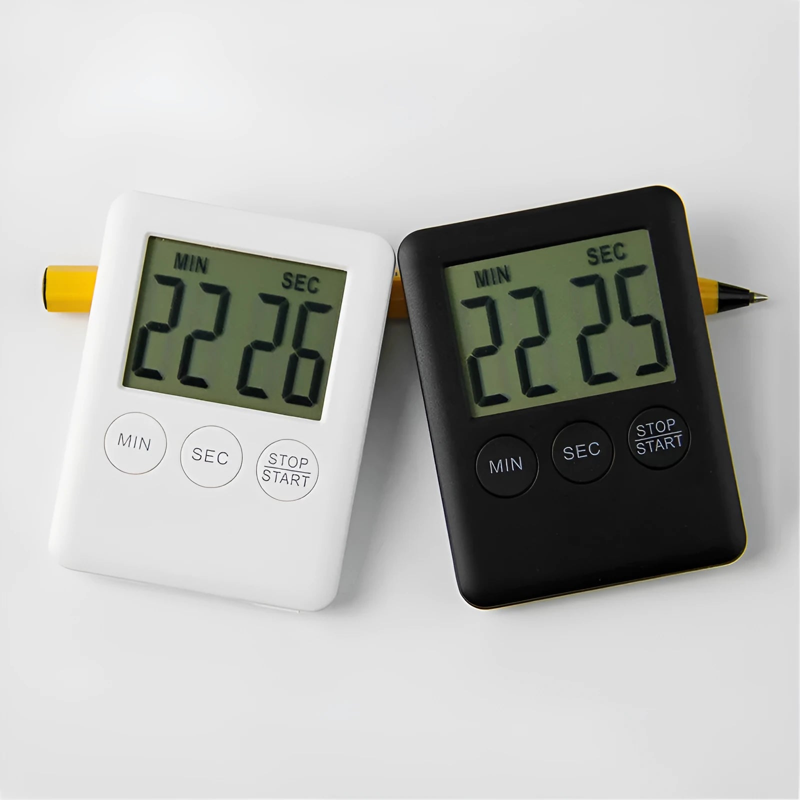 Black and white mechanical kitchen timer with magnetic back showing 60-minute dial.