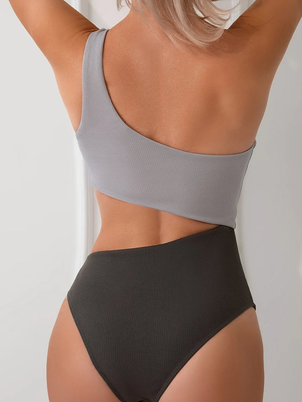 Light grey one-shoulder one-piece swimsuit on a model