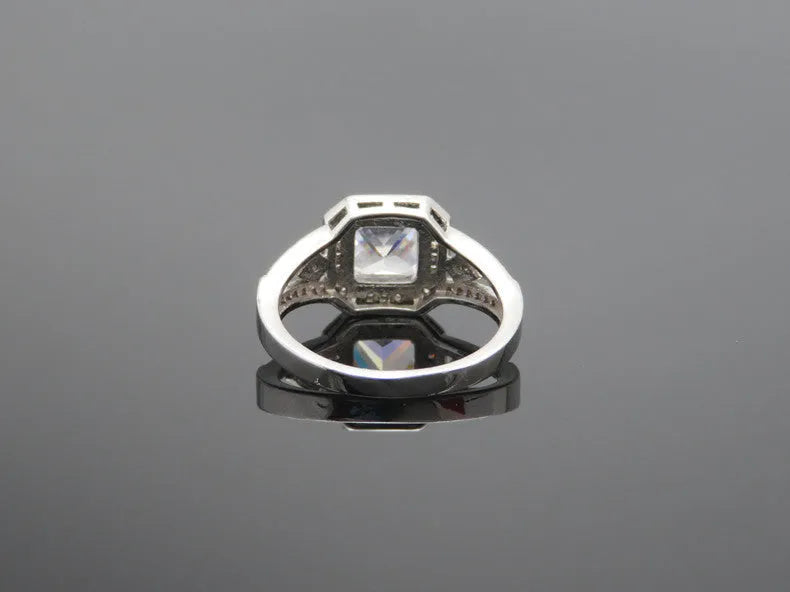 Geometric hollow zircon ring in platinum colour with four-sided design on woman's finger