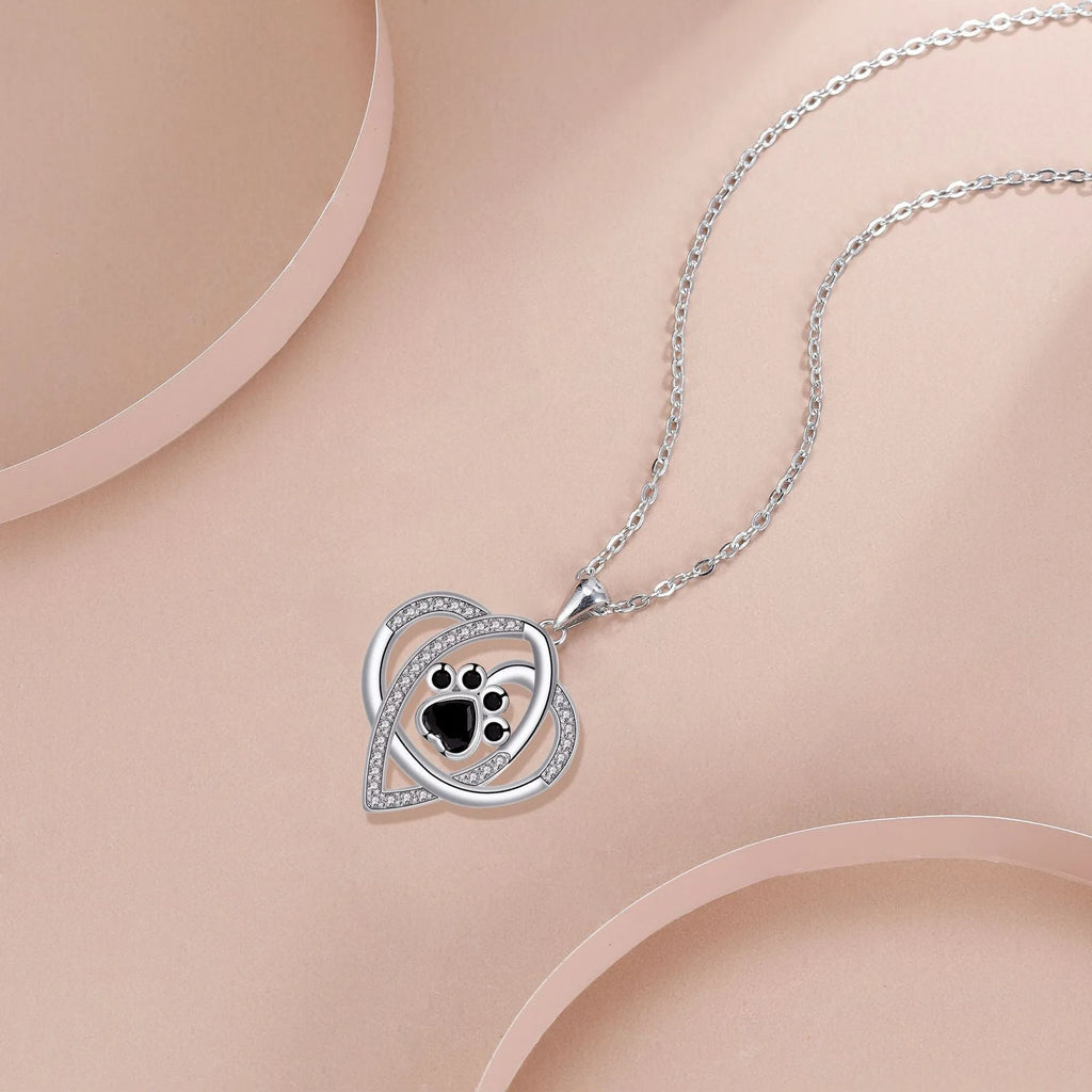 Copper necklace for women showing a pendant with dog paw and cat footprints design on a cross chain.