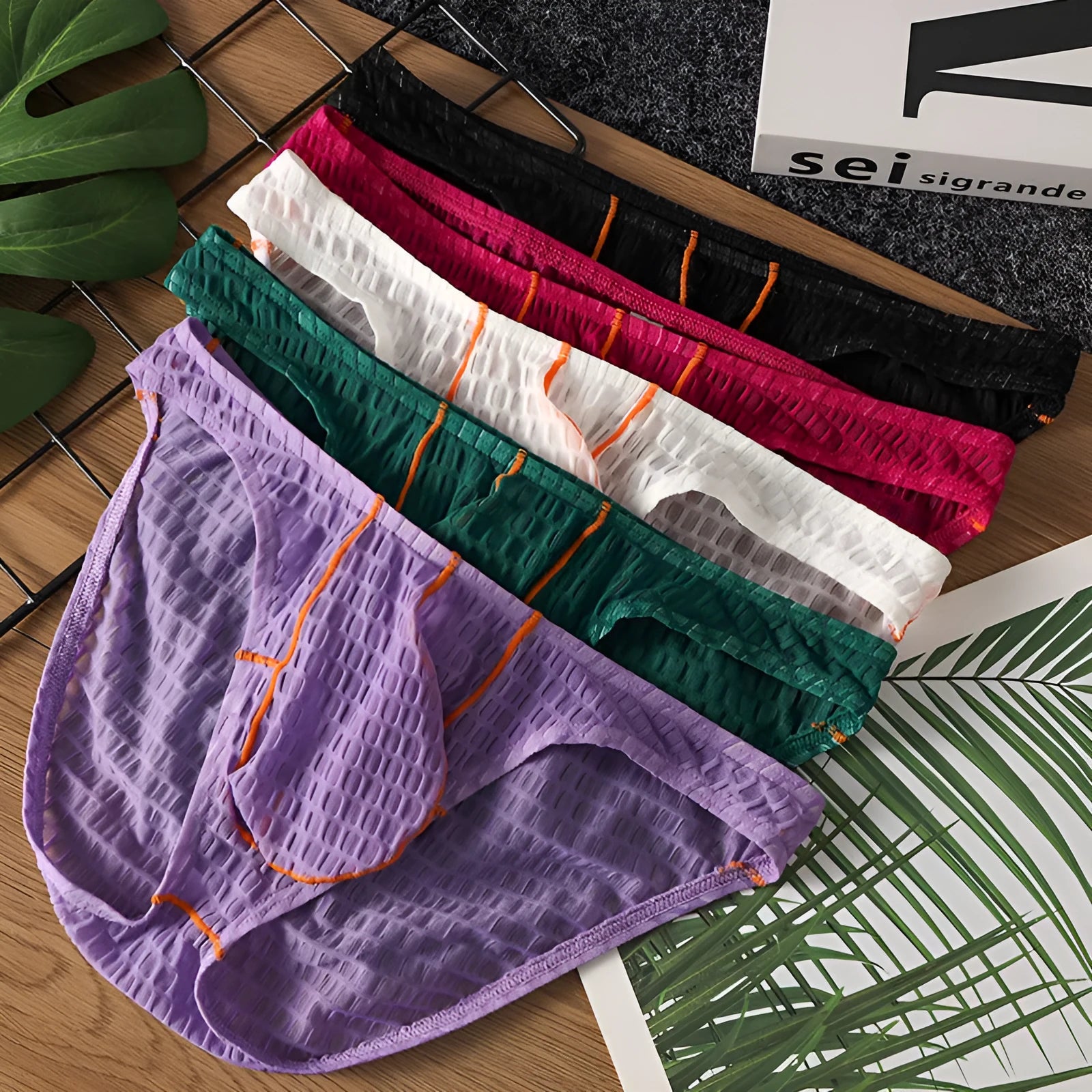 Men's low waist lace briefs in white, black, green, rose red, or light purple on a plain background.