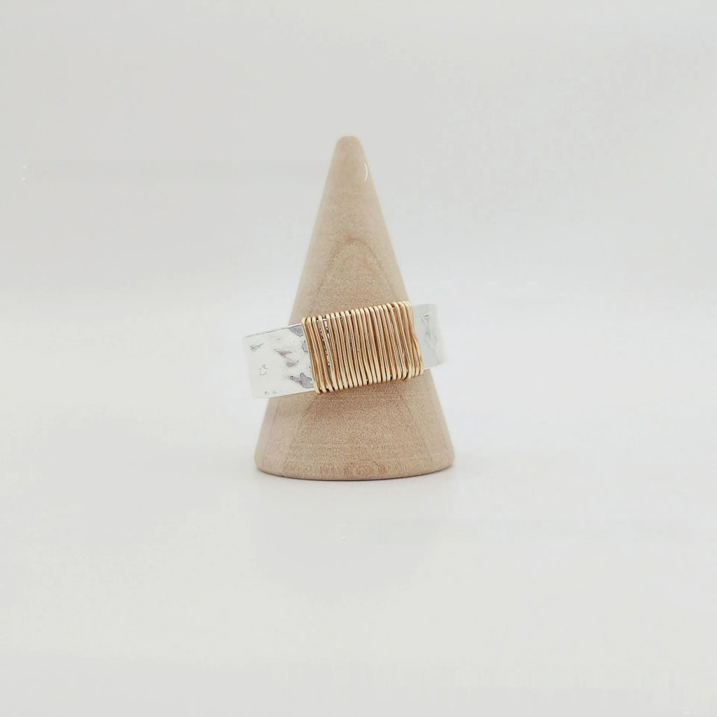 Silver golden geometric copper bracelet with an irregular coil and wide face ring design.