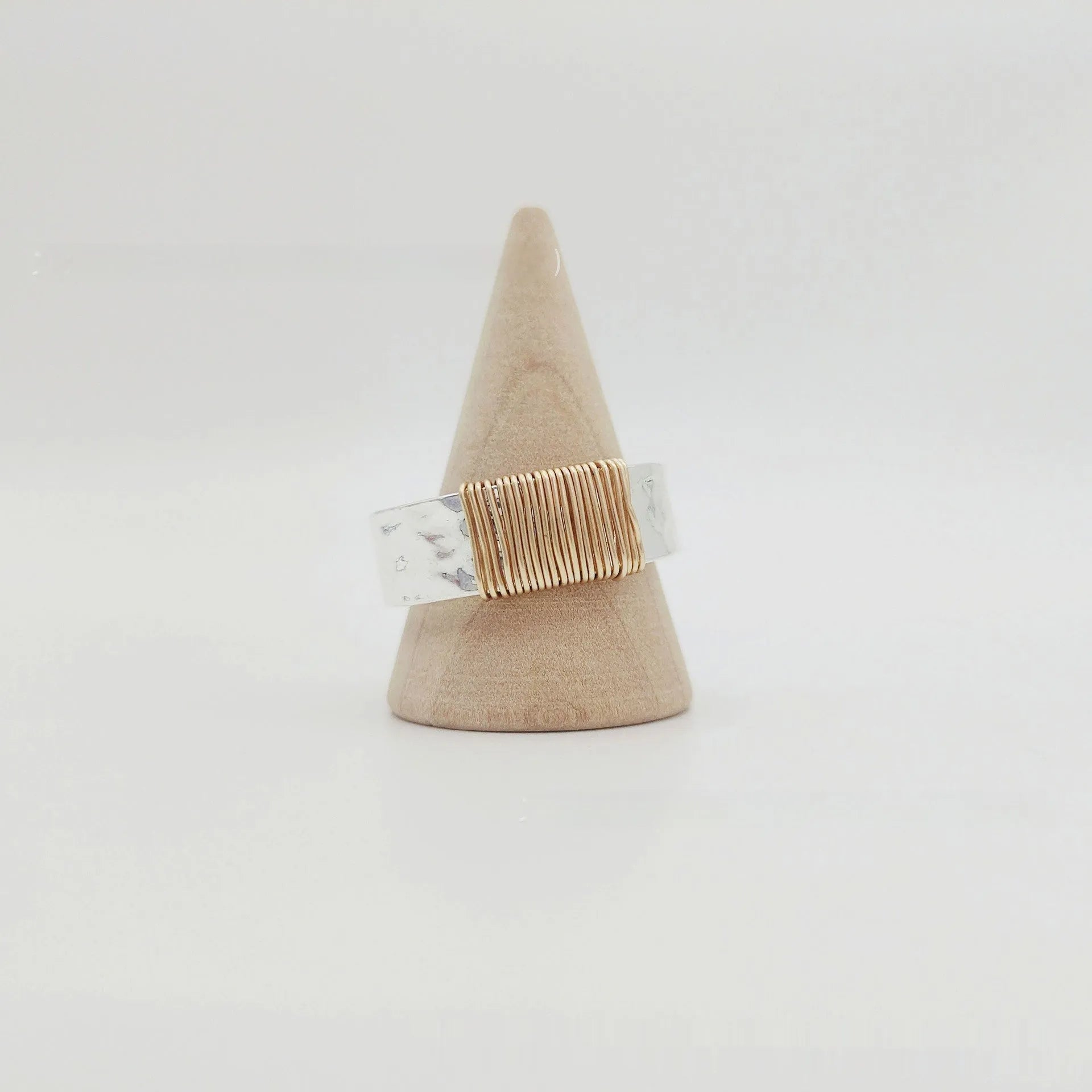 Silver golden geometric copper bracelet with an irregular coil and wide face ring design.