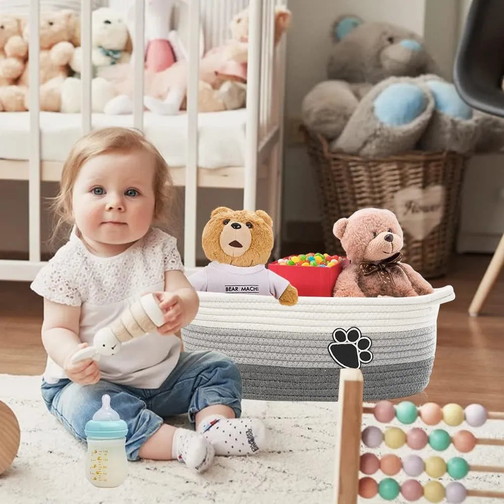 Light beige handmade cotton rope storage basket with a handle on a wooden floor.