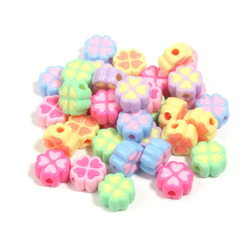 Assortment of frosted acrylic four-leaf clover shaped beads in rose red, pink, yellow, green, blue, and purple colours.