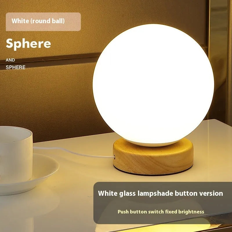 Nordic solid wood base USB table lamp with a white geometric shade on a wooden table.