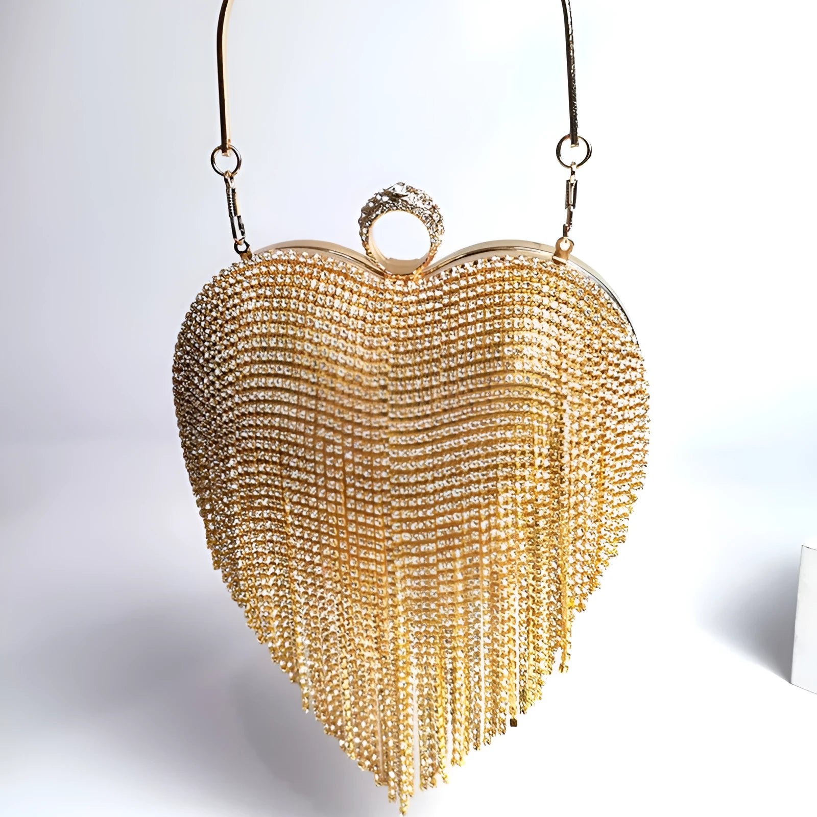 Women's heart-shaped metal dinner bag with tassel detail in black, gold, and silver options