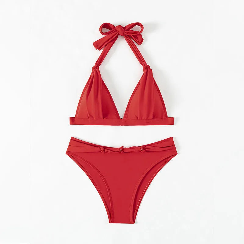 Red women's lace-up halterneck bikini with split shorts on a mannequin.