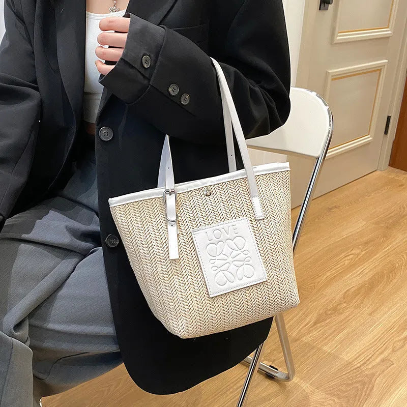 Women's woven straw shoulder bag in retro style with three-dimensional pocket and visible sewing thread details