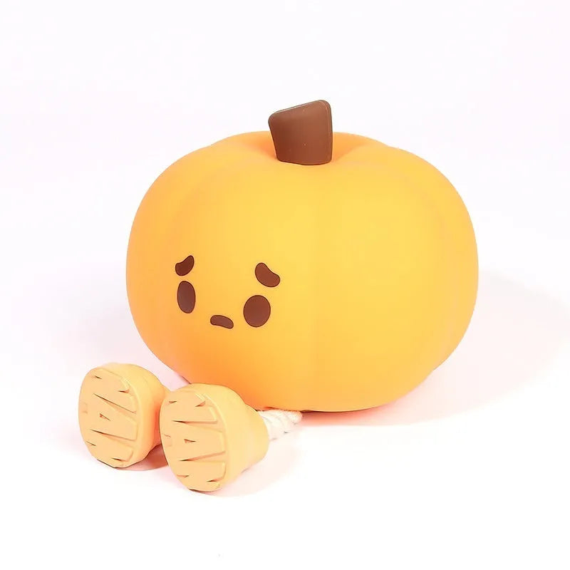 Pumpkin-shaped small night lamp in orange silicone with racket style design on table
