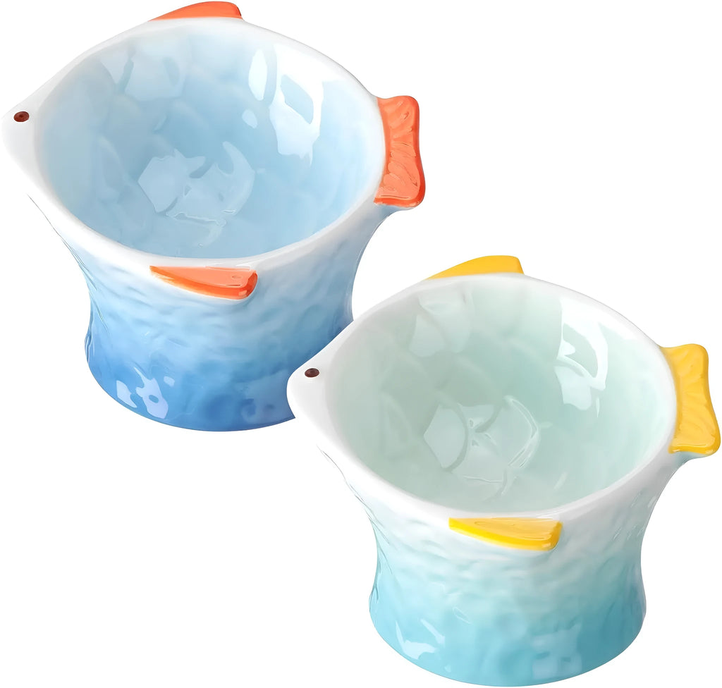 Blue fish-shaped ceramic cat feeder bowl with shallow tilt angle and non-slip base on a wooden surface.