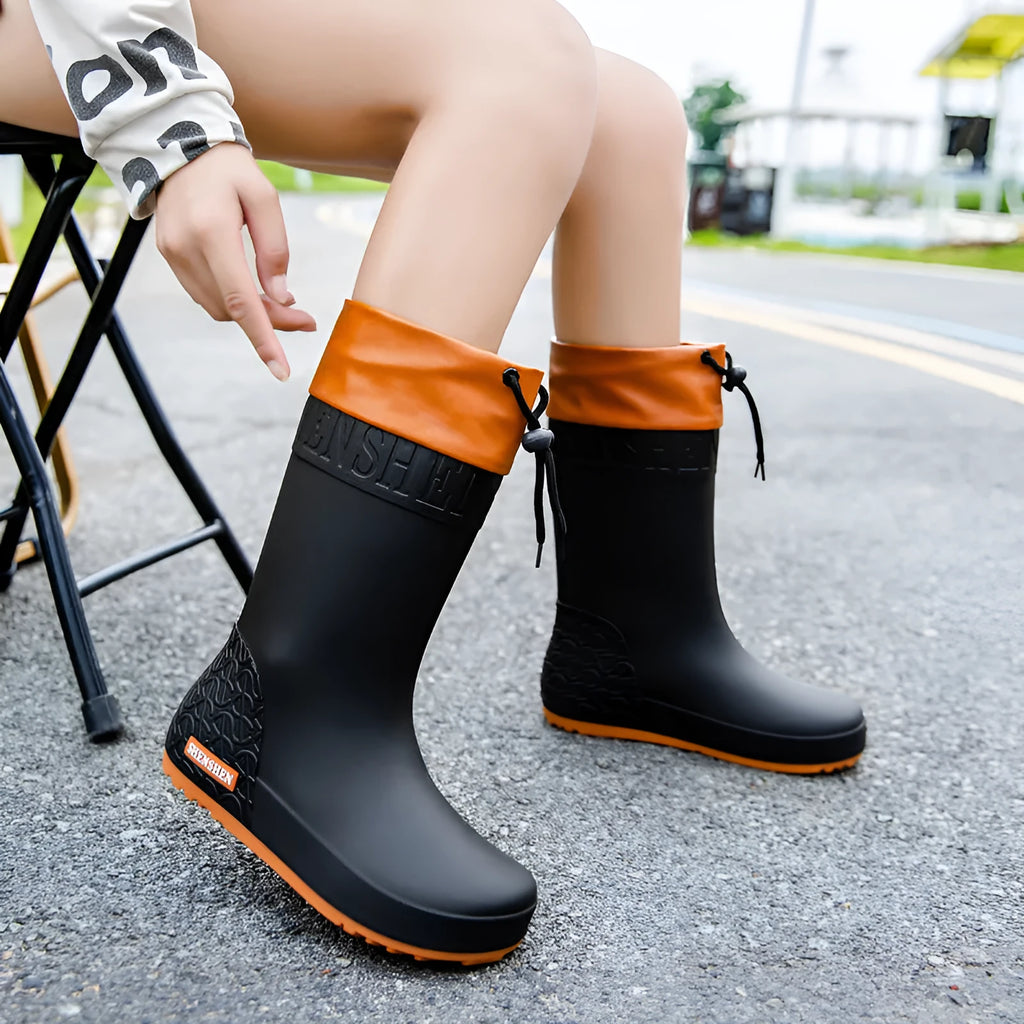 Women's solid colour PVC rain boots with non-slip sole in apricot, black, brown, and pink.