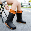 Women's solid colour PVC rain boots with non-slip sole in apricot, black, brown, and pink.