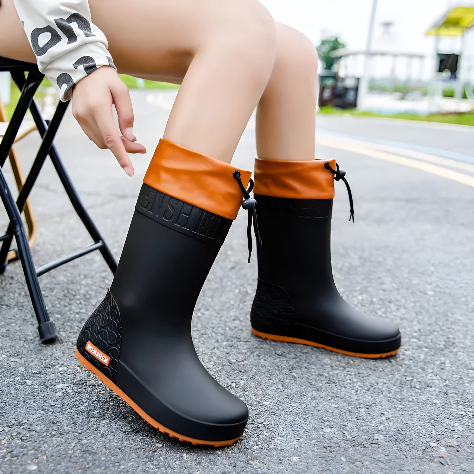 Women's solid colour PVC rain boots with non-slip sole in apricot, black, brown, and pink.
