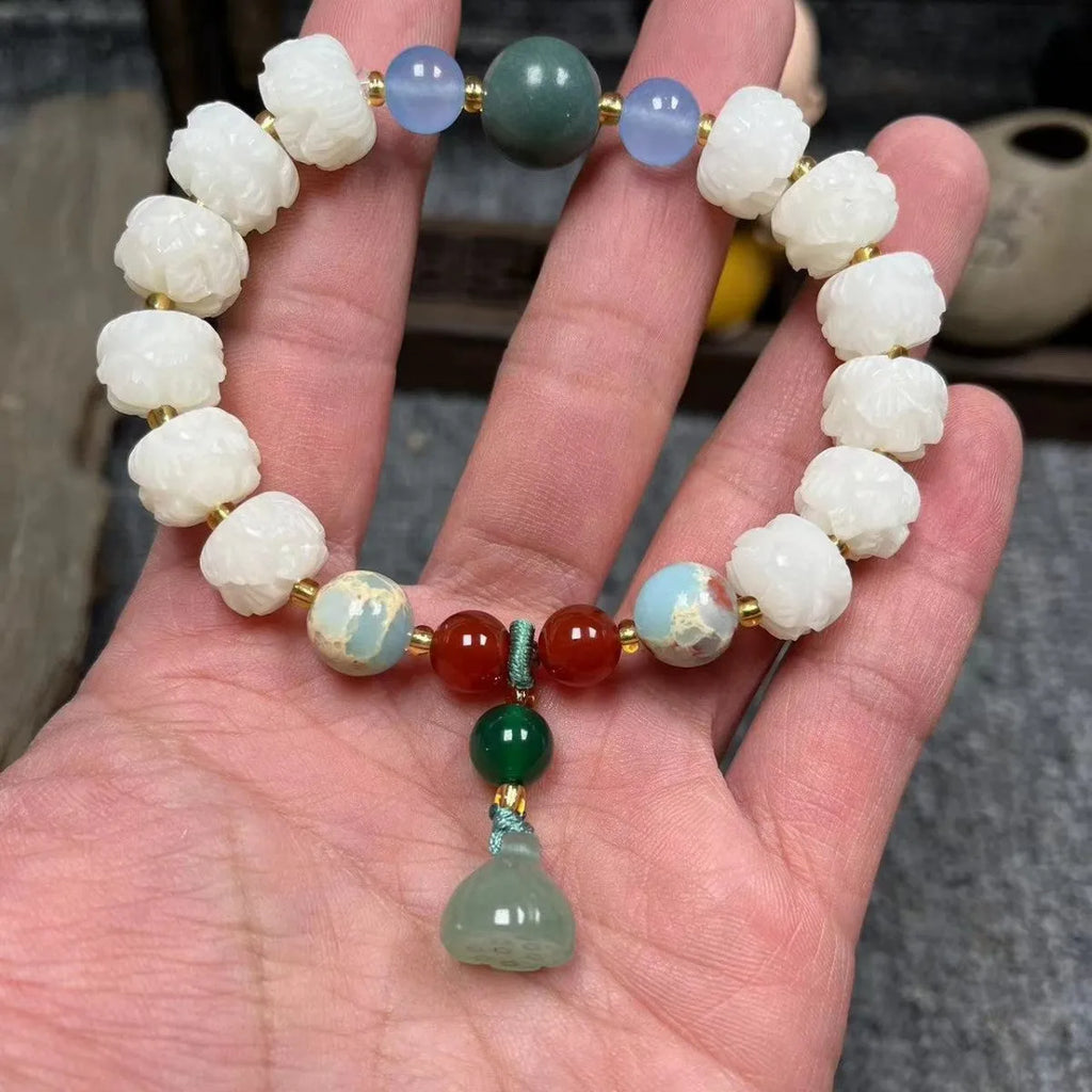 Carved Bodhi root bracelet with white jade, lotus, and pumpkin beads in various sizes.