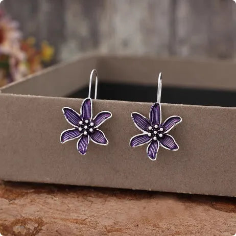 A pair of purple flower-shaped alloy earrings with an electroplated finish.