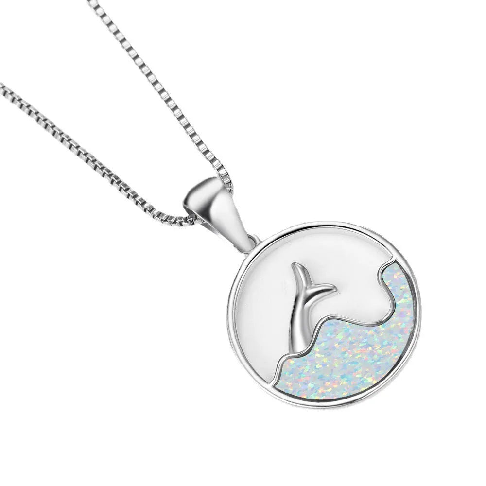 A round geometric fishtail pendant necklace with a white gold electroplated finish, shown in blue opal and white opal colour options.